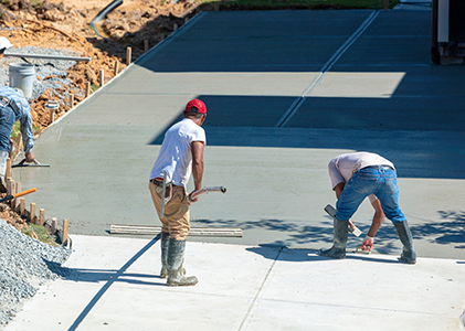 Crew smoothing and finishing a freshly poured concrete driveway in Clearwater, FL