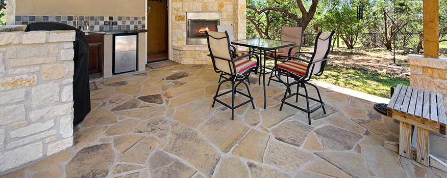 Outdoor patio with stone flooring, dining set, and a built-in fireplace at a Tampa Bay home