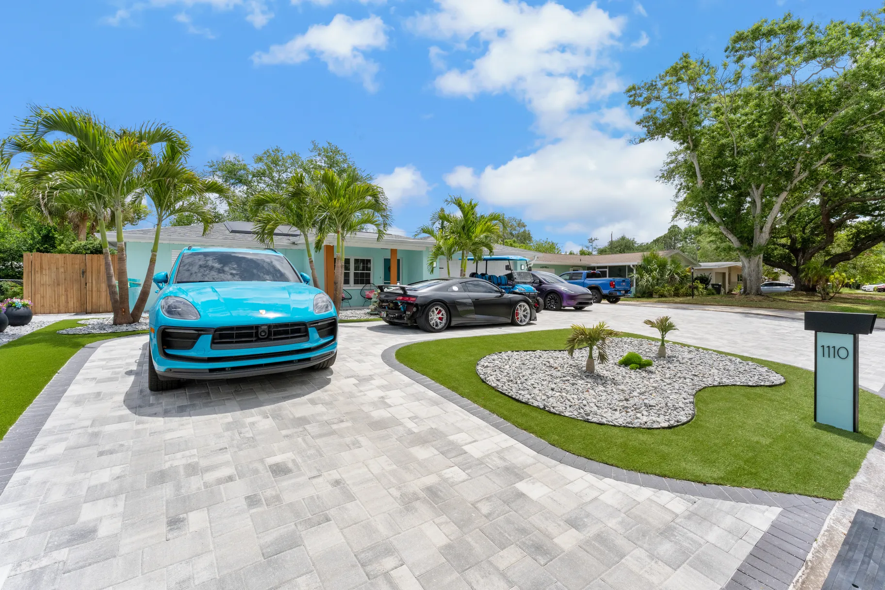 Gray brick paver driveway at a modern Tampa Bay home with palm trees and landscaping